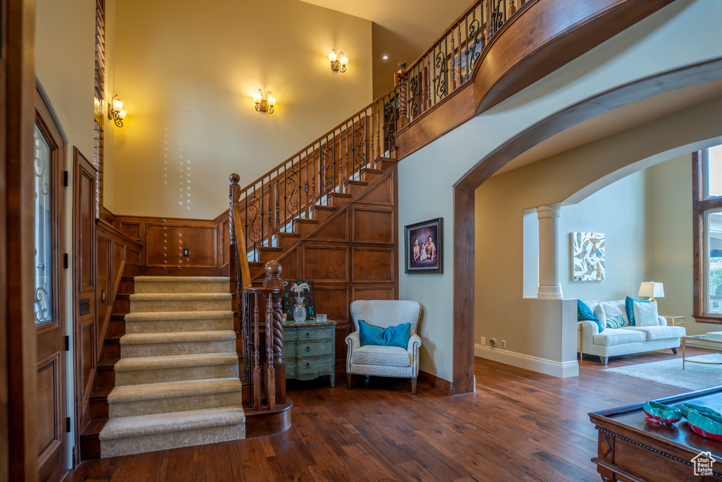 Entryway featuring decorative columns, a high ceiling, and dark wood-type flooring