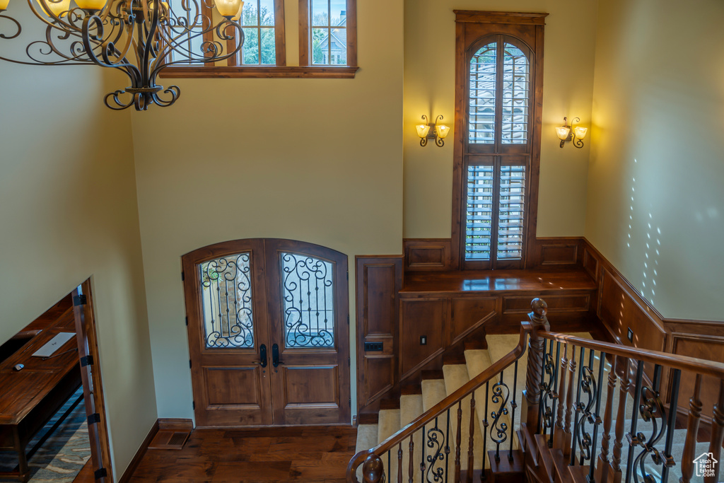 Foyer featuring french doors, dark hardwood / wood-style flooring, a high ceiling, and a chandelier