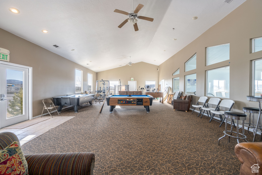 Carpeted living room with billiards, high vaulted ceiling, and ceiling fan
