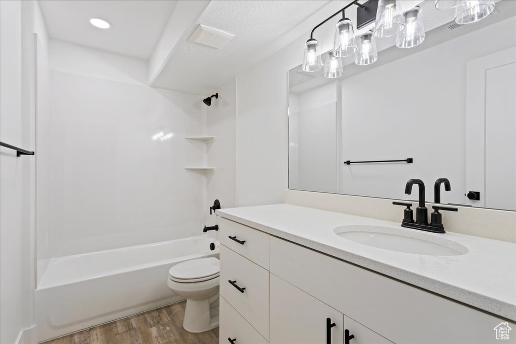 Full bathroom featuring toilet, bathing tub / shower combination, vanity, and hardwood / wood-style flooring