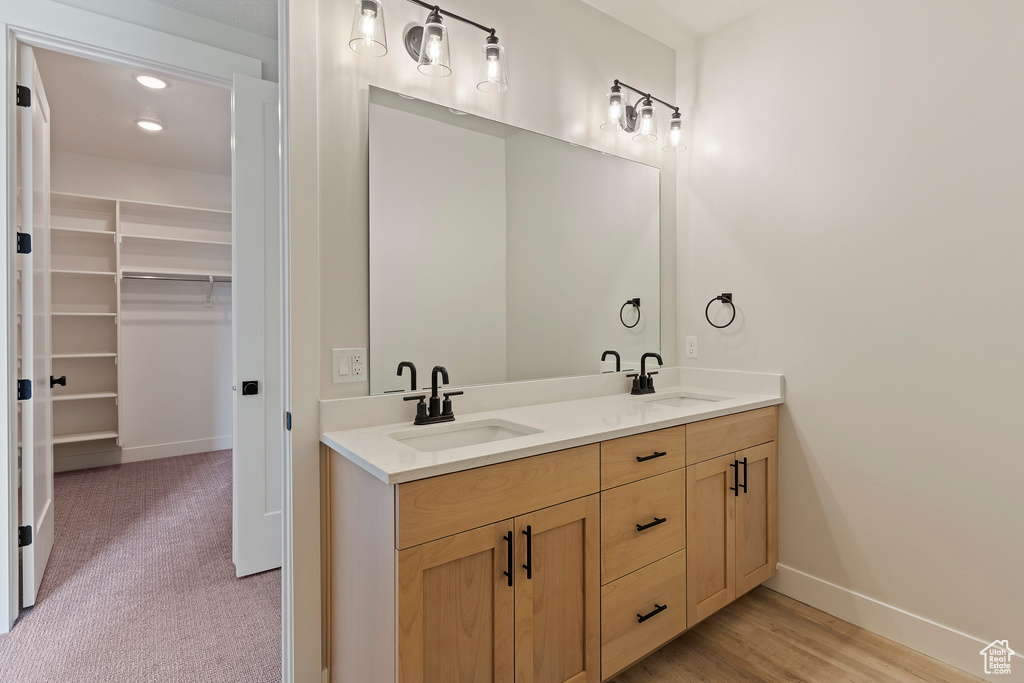 Bathroom with dual bowl vanity and hardwood / wood-style flooring