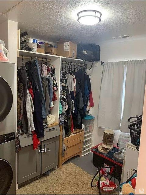 Walk in closet with stacked washer / dryer