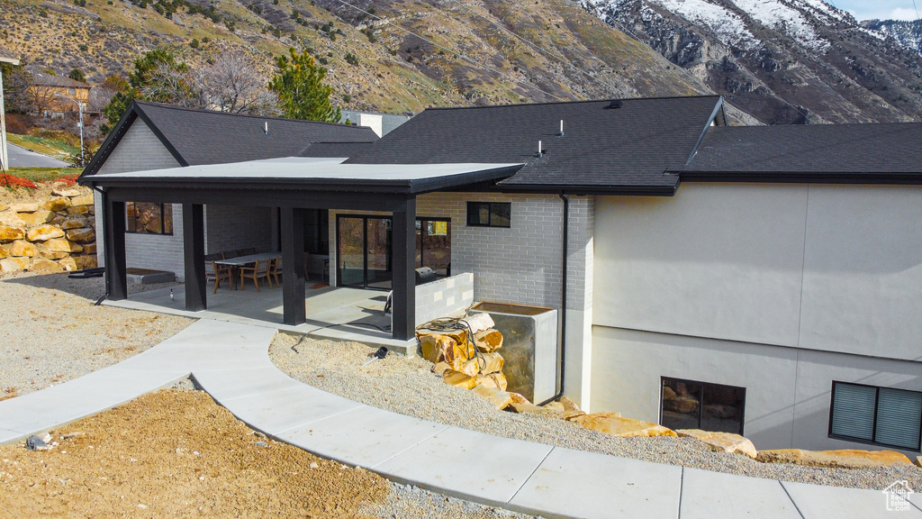 View of front of property with a mountain view and a patio area
