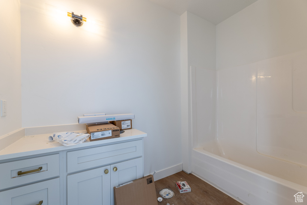 Bathroom featuring vanity, shower / bathing tub combination, and wood-type flooring