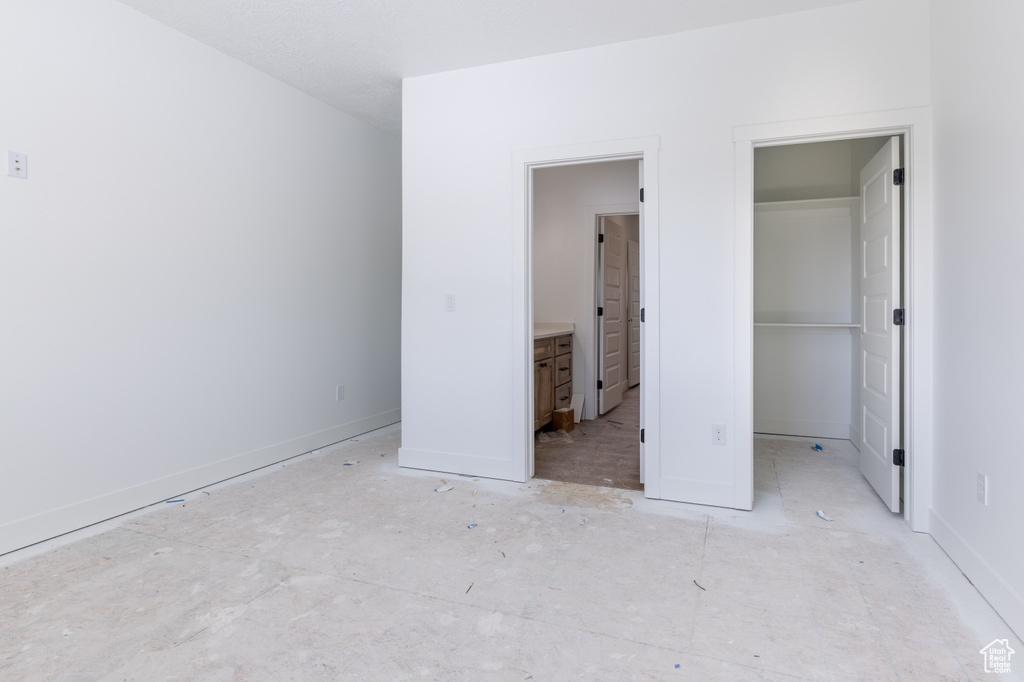 Unfurnished bedroom with a spacious closet and ensuite bathroom