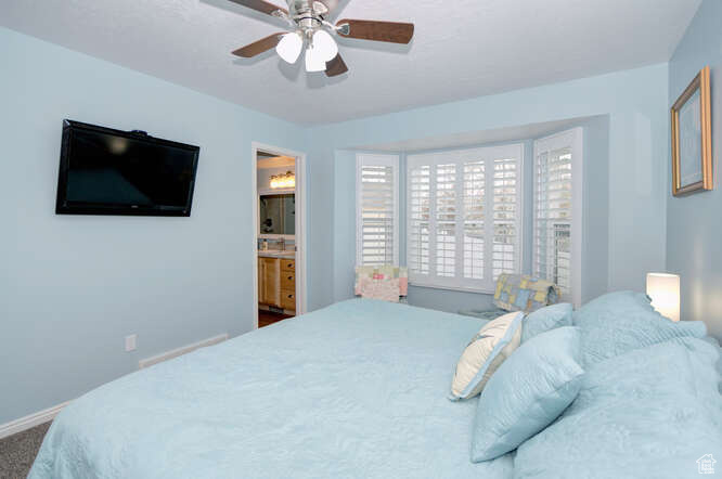 Bedroom featuring ensuite bathroom and ceiling fan