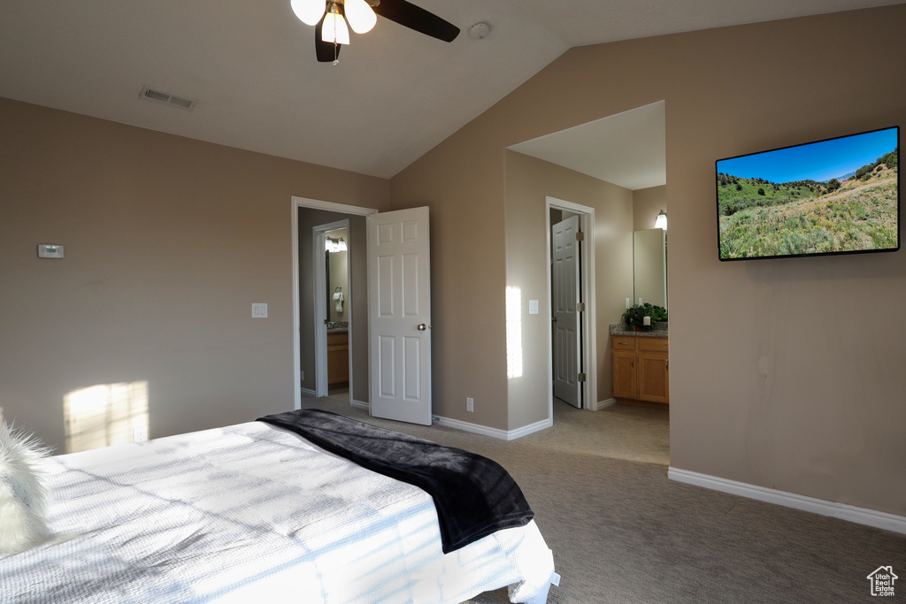 Bedroom featuring vaulted ceiling, light colored carpet, connected bathroom, and ceiling fan