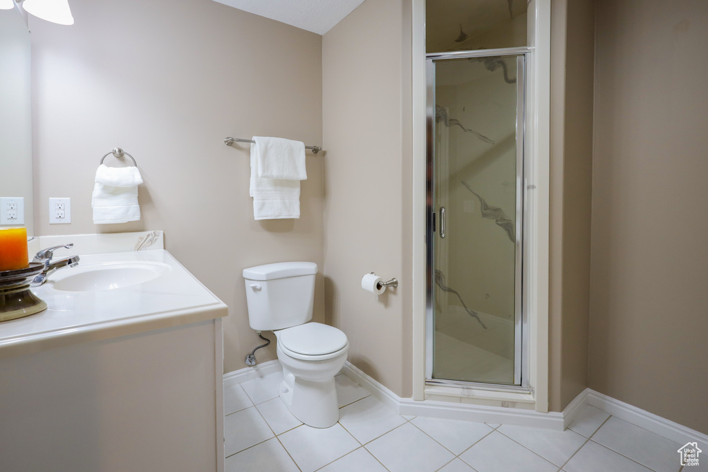 Bathroom with vanity, tile flooring, an enclosed shower, ceiling fan, and toilet