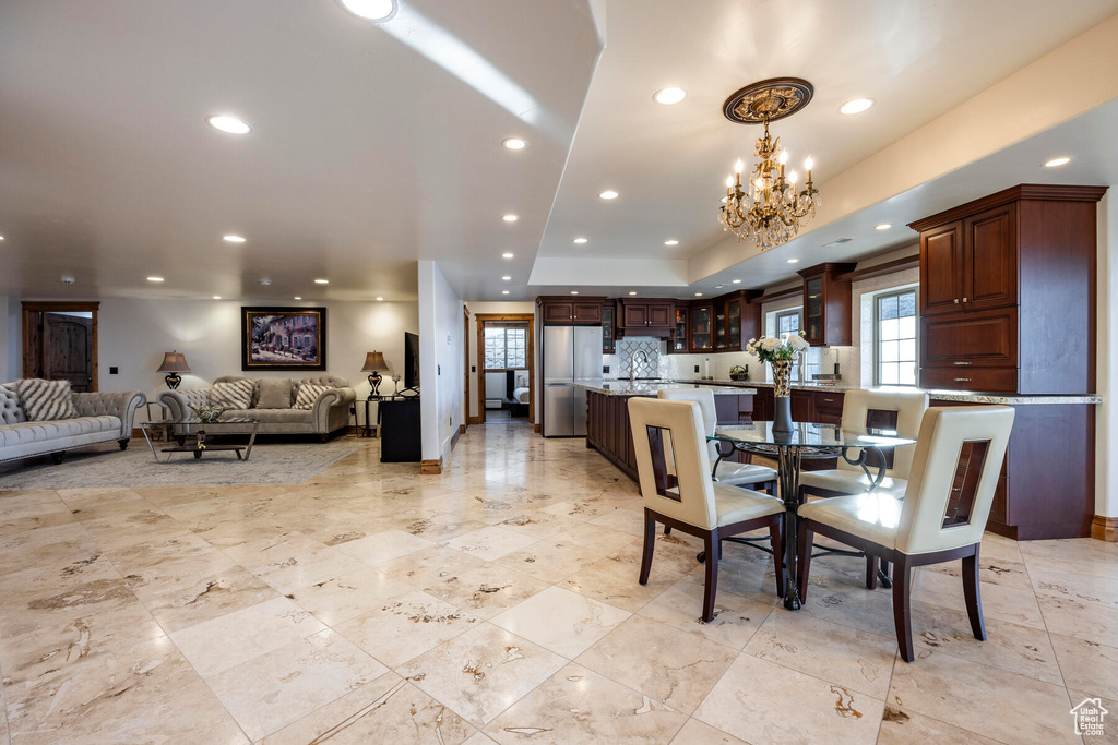 Dining space with light tile flooring and a chandelier