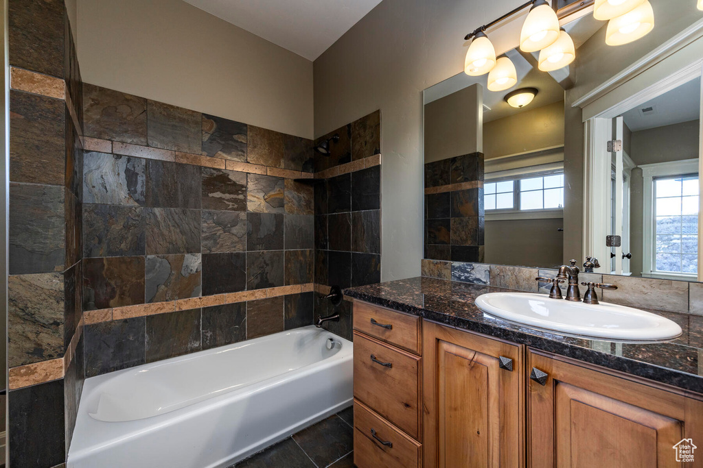 Bathroom with vanity, tile floors, and tiled shower / bath