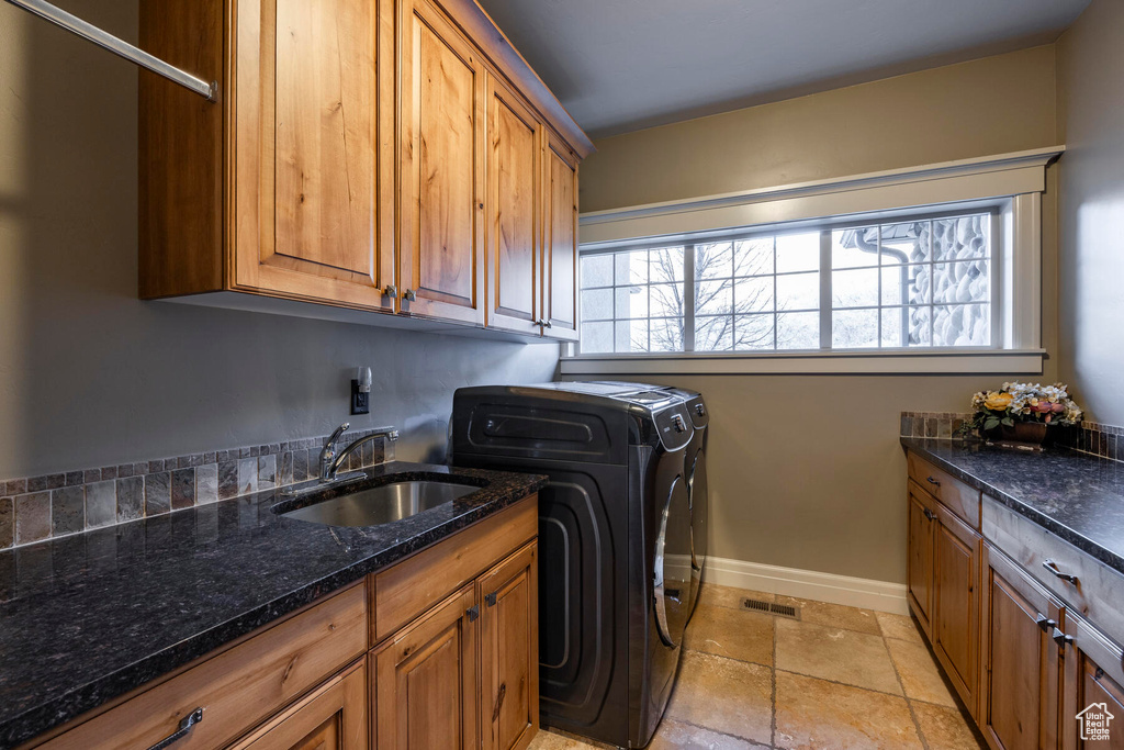 Laundry room with cabinets, sink, light tile flooring, and independent washer and dryer