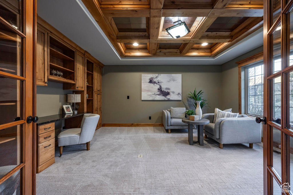 Carpeted home office with french doors, beam ceiling, and coffered ceiling
