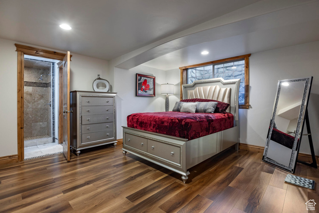 Bedroom with ensuite bathroom and dark hardwood / wood-style flooring