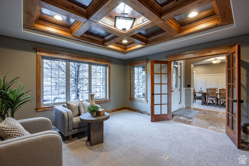 Interior space featuring coffered ceiling, french doors, light carpet, a skylight, and beam ceiling