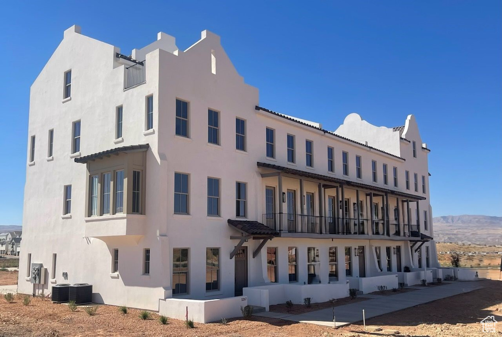 View of building exterior featuring a mountain view and cooling unit