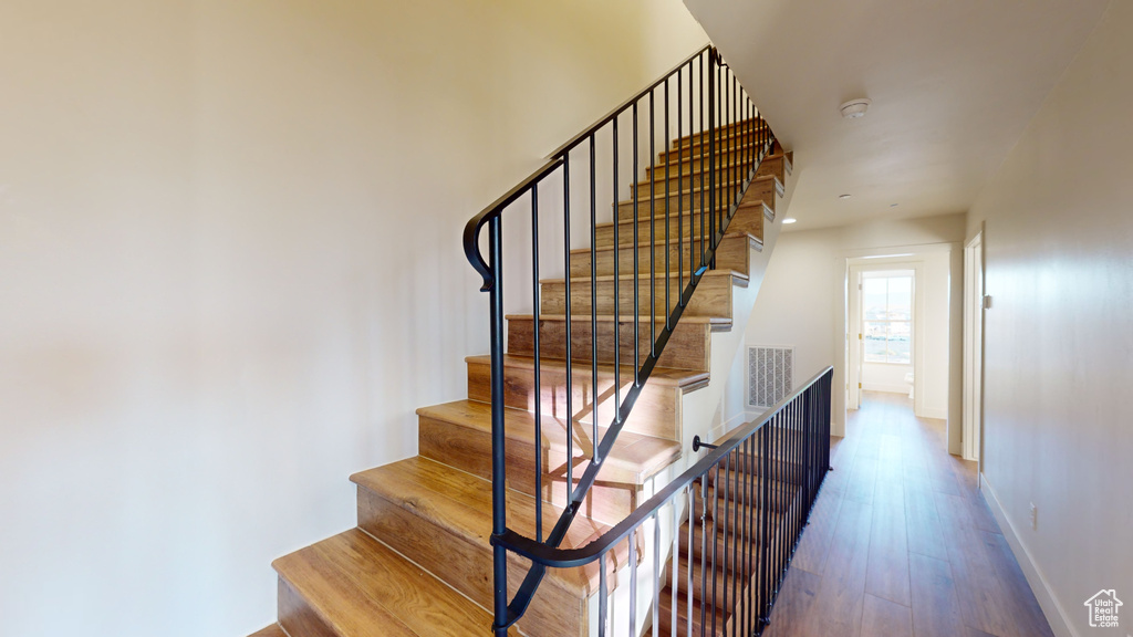 Staircase featuring hardwood / wood-style flooring