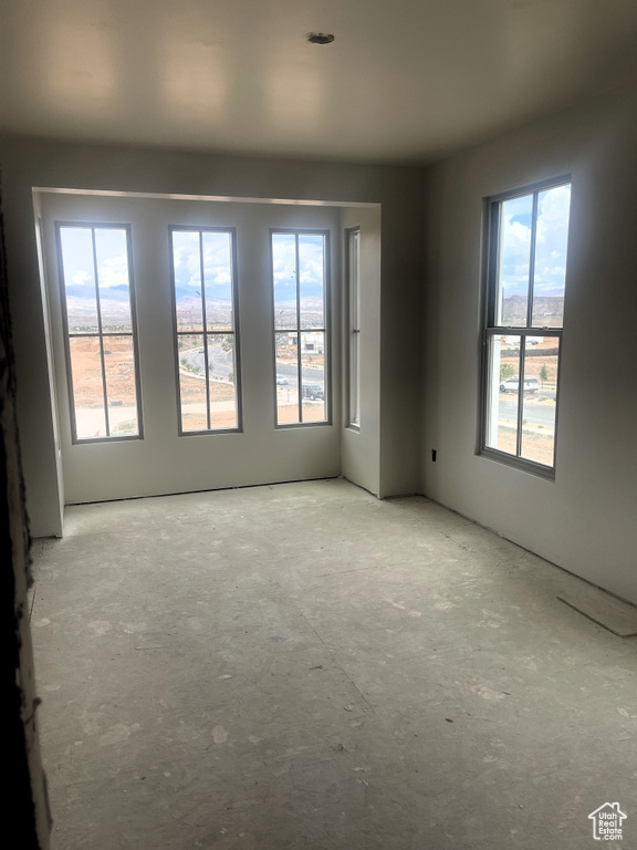 Empty room featuring concrete floors and a wealth of natural light