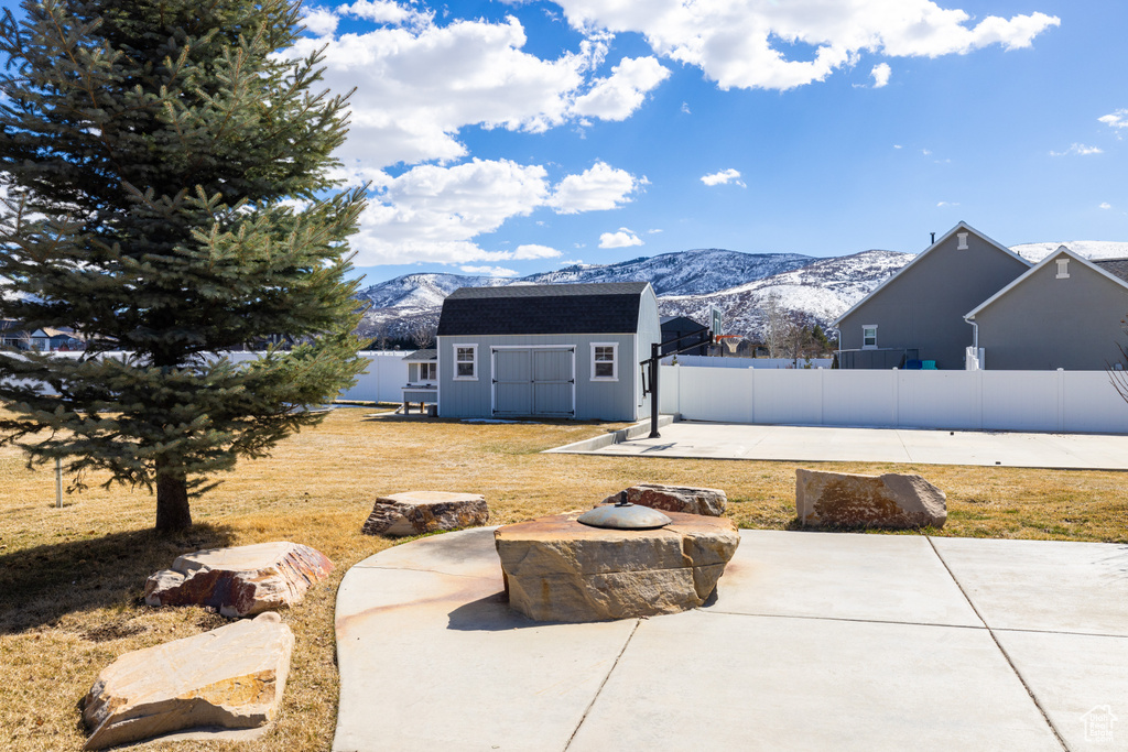 Exterior space featuring an outdoor fire pit, a mountain view, and an outdoor structure