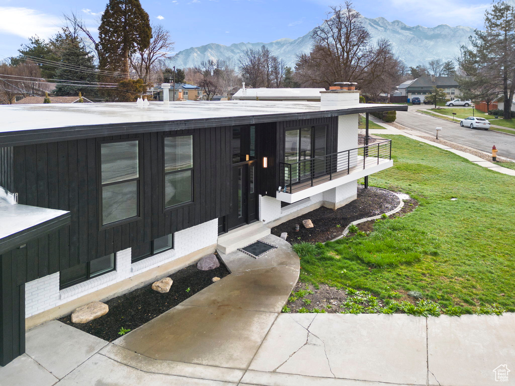 Exterior space featuring a front lawn and a mountain view