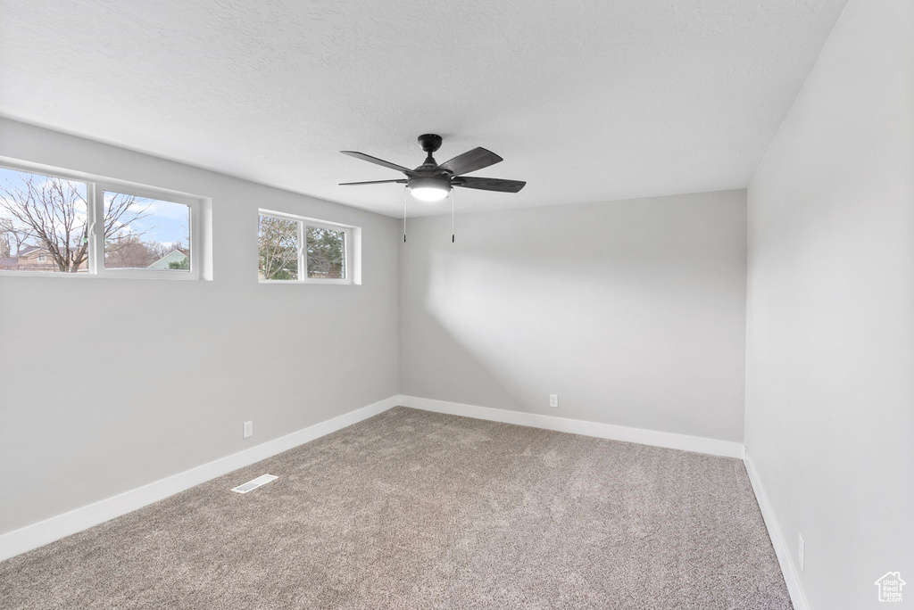 Empty room featuring carpet and ceiling fan
