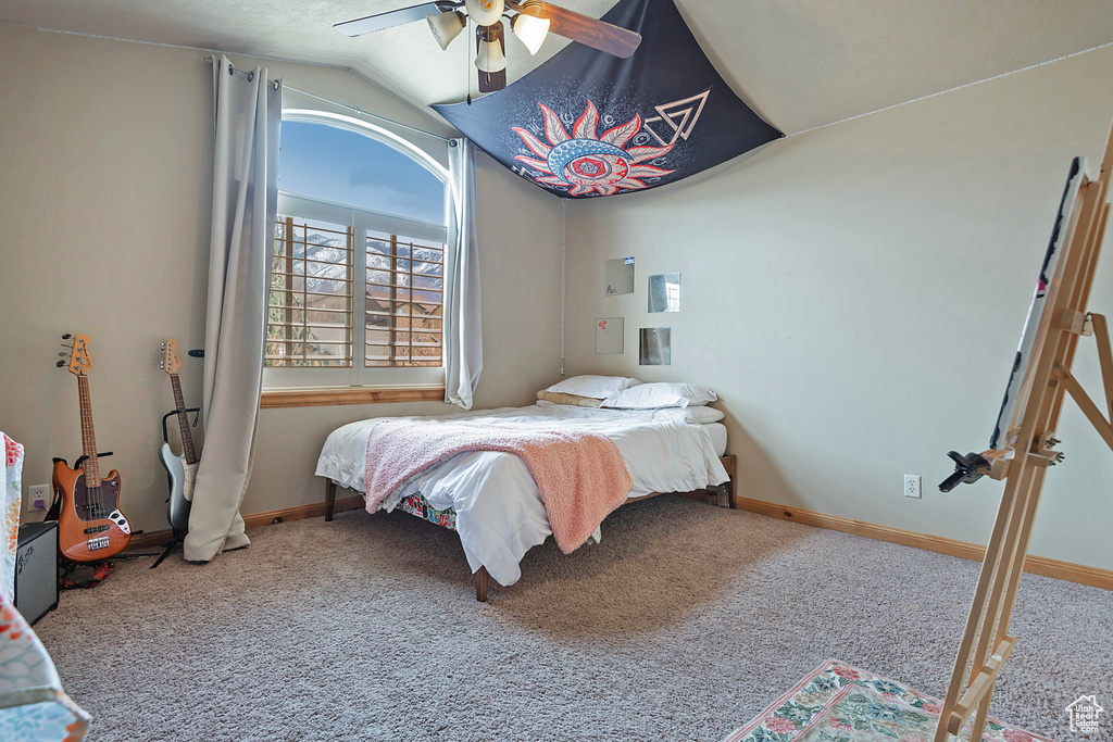 Bedroom with light colored carpet, lofted ceiling, and ceiling fan