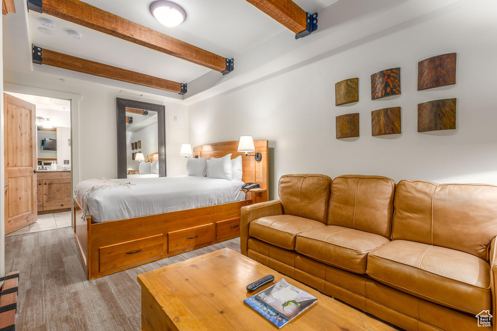 Tiled bedroom with ensuite bath and beam ceiling