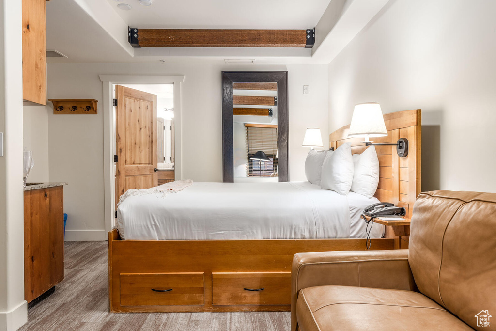 Bedroom featuring a tray ceiling and light wood-type flooring