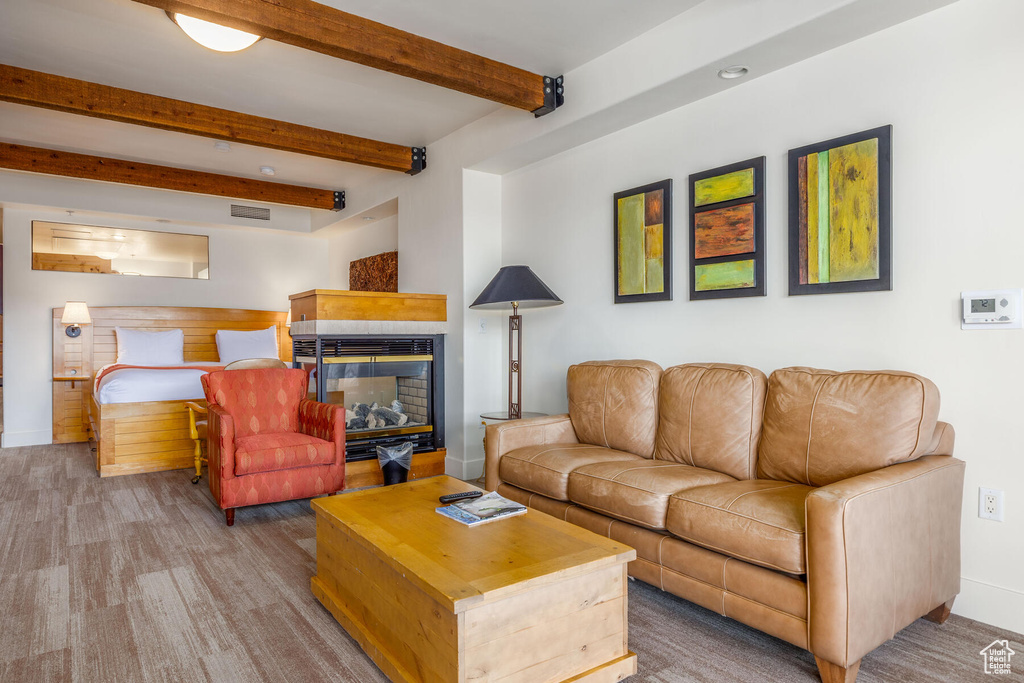 Living room featuring a multi sided fireplace and beam ceiling