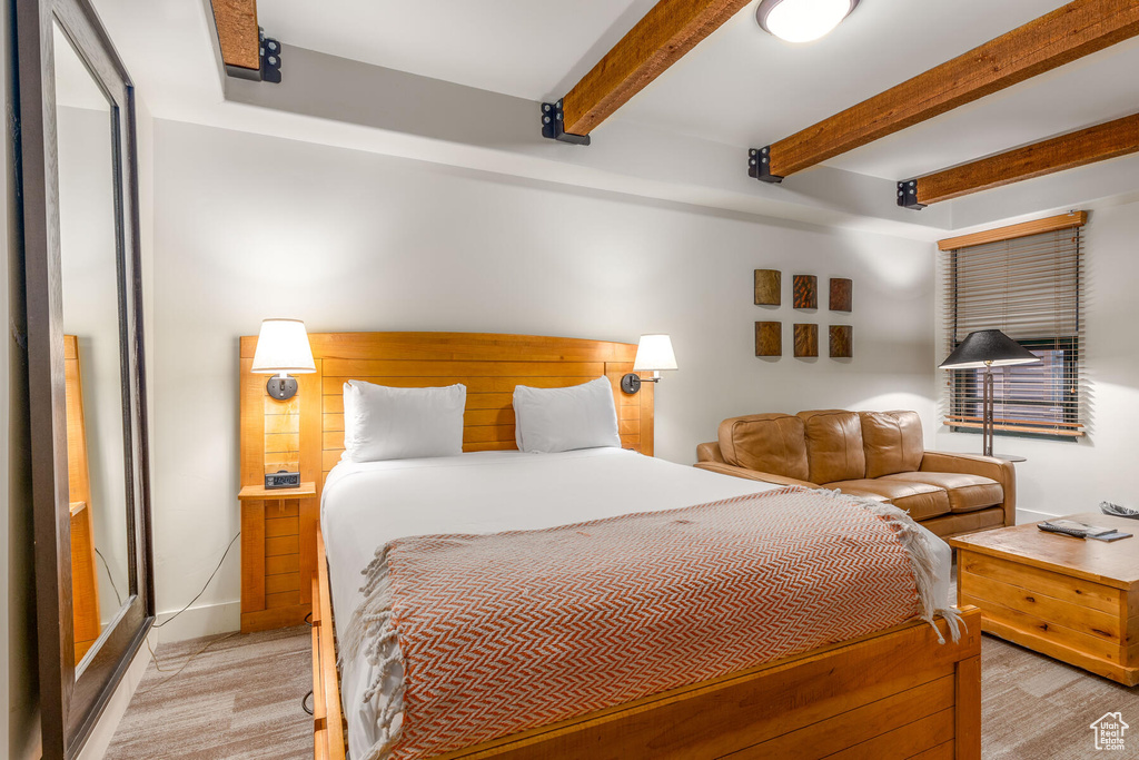 Carpeted bedroom featuring beamed ceiling