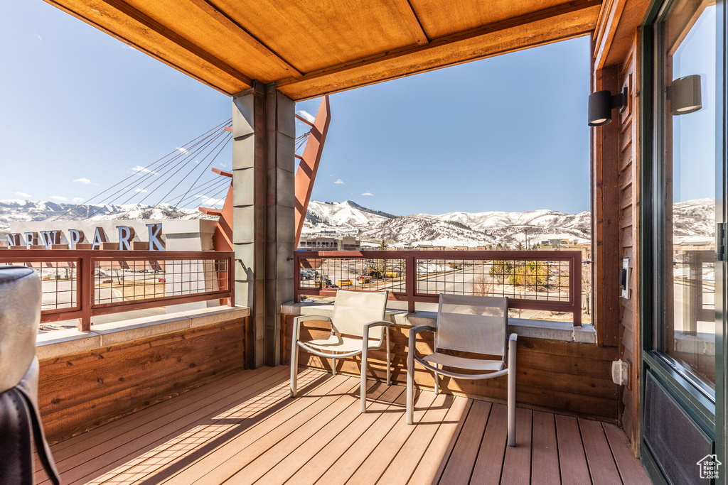 Snow covered deck featuring a mountain view