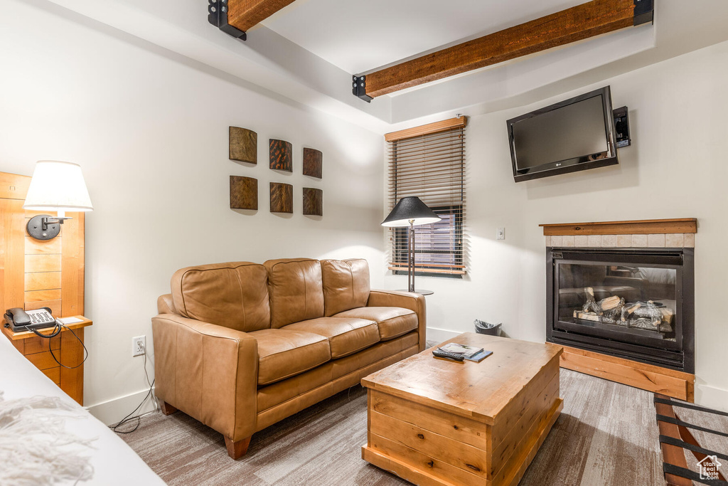 Living room with wood-type flooring and beam ceiling