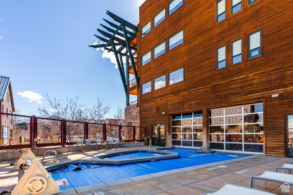 View of swimming pool featuring a hot tub