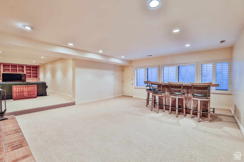 Dining room featuring indoor bar and light colored carpet