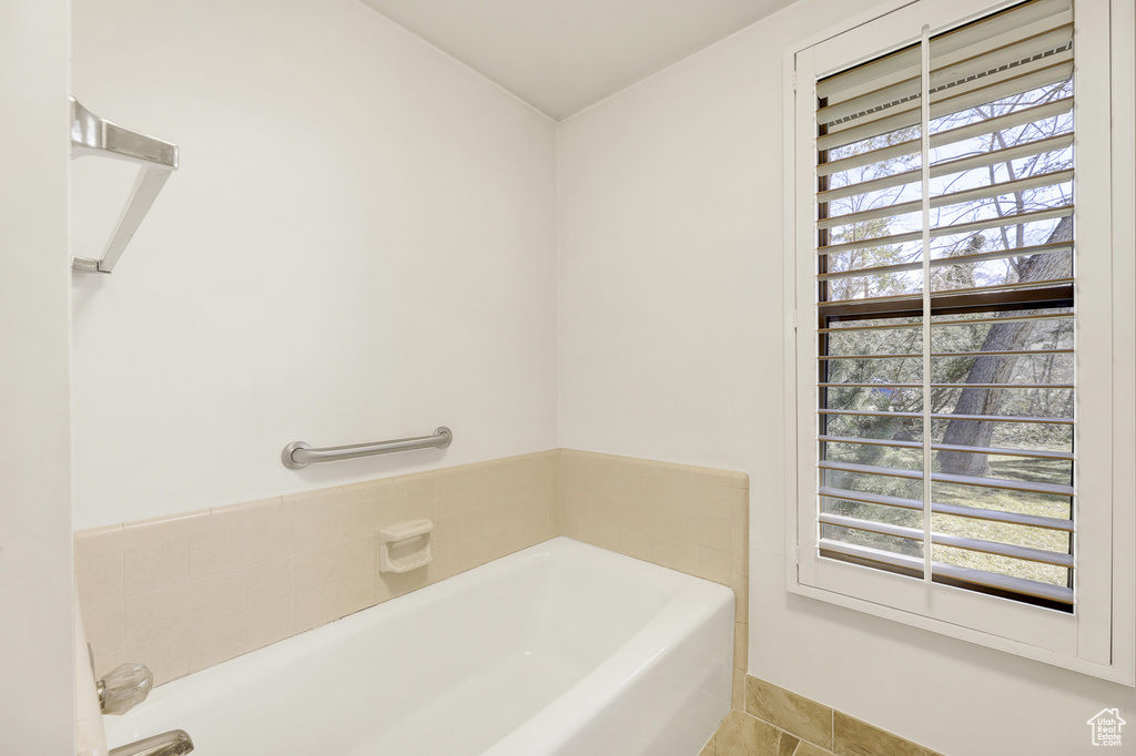 Bathroom featuring a washtub, tile floors, and a wealth of natural light