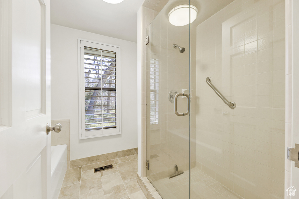 Bathroom featuring tile flooring and a shower with shower door