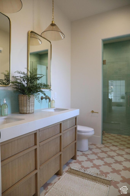 Bathroom featuring vanity, toilet, walk in shower, and tile floors