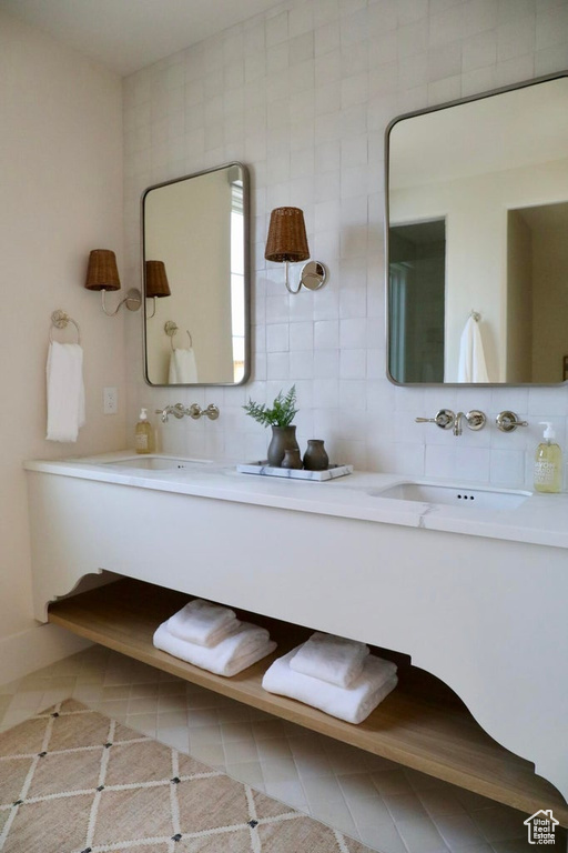 Bathroom featuring double sink vanity, backsplash, tile flooring, and tile walls
