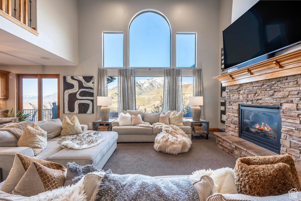Living room featuring a fireplace, a mountain view, carpet flooring, and a high ceiling