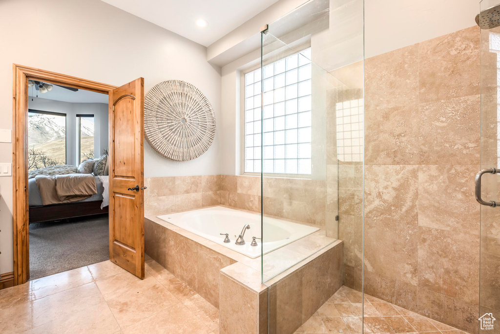 Bathroom with tile flooring, a wealth of natural light, and independent shower and bath