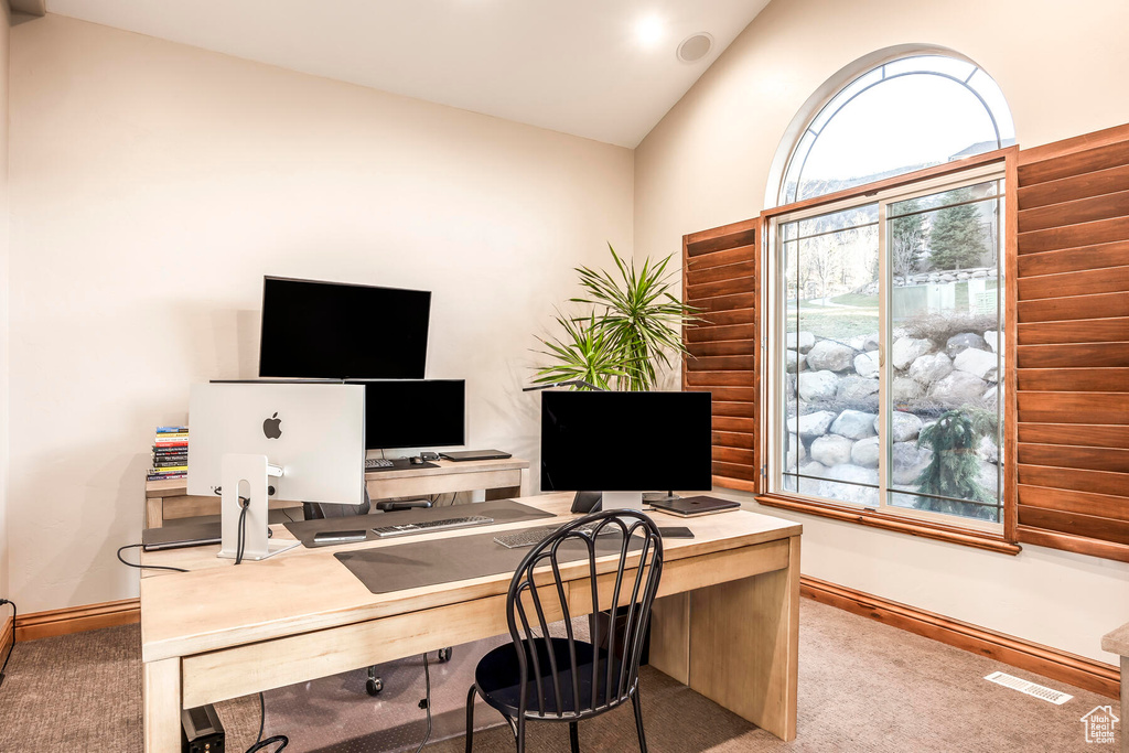 Carpeted home office featuring vaulted ceiling