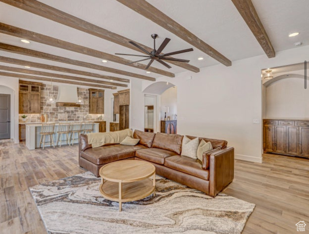 Living room featuring ceiling fan, beamed ceiling, and light hardwood / wood-style floors