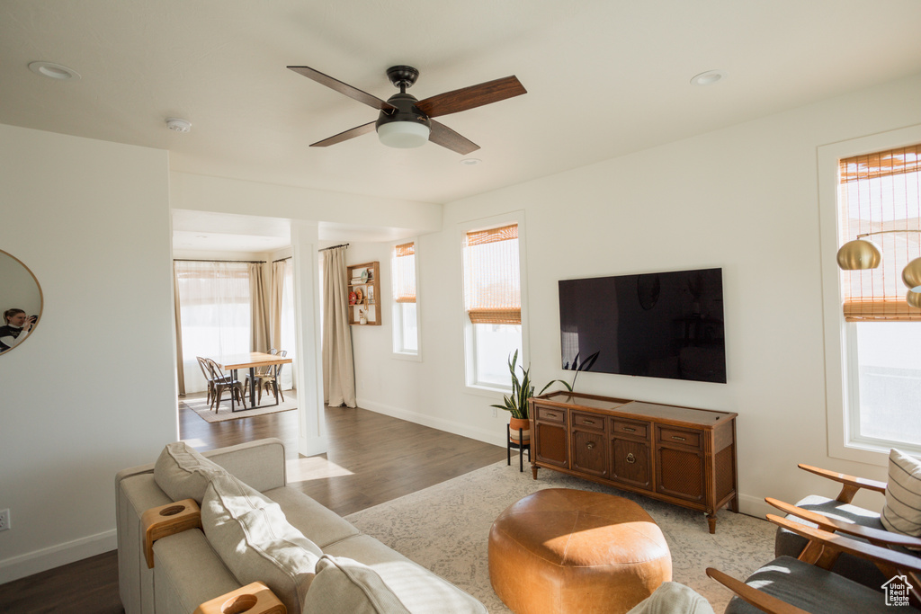 Living room with ceiling fan, a healthy amount of sunlight, and dark hardwood / wood-style floors