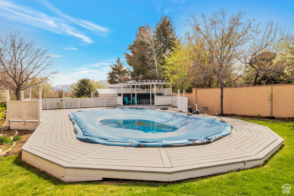 View of swimming pool with a wooden deck and a pergola