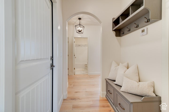 Mudroom featuring a notable chandelier and light hardwood / wood-style floors