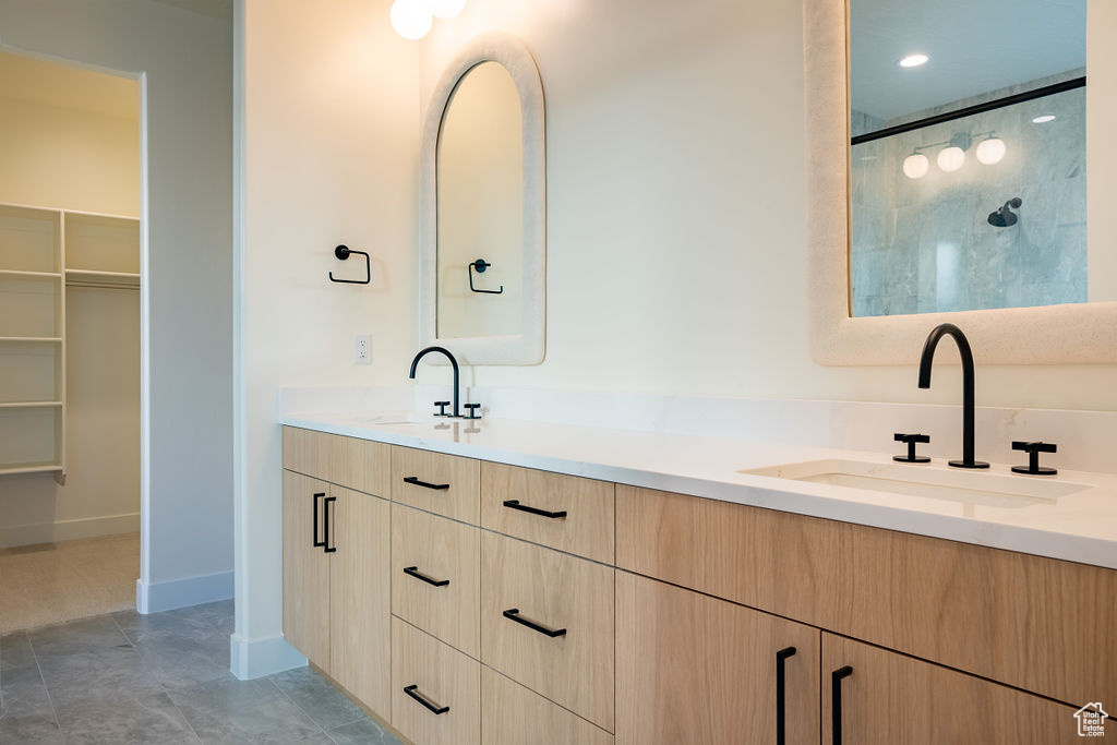 Bathroom featuring dual bowl vanity and tile floors