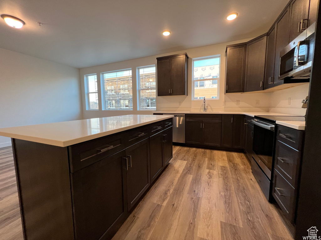Kitchen featuring appliances with stainless steel finishes, a wealth of natural light, and light hardwood / wood-style flooring