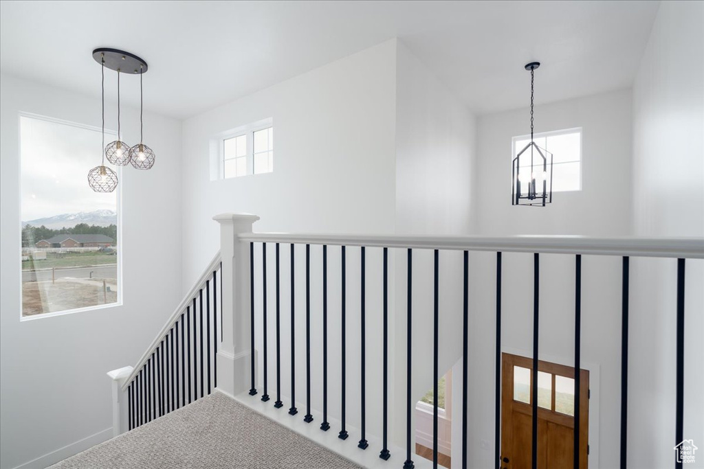 Staircase with an inviting chandelier and carpet flooring