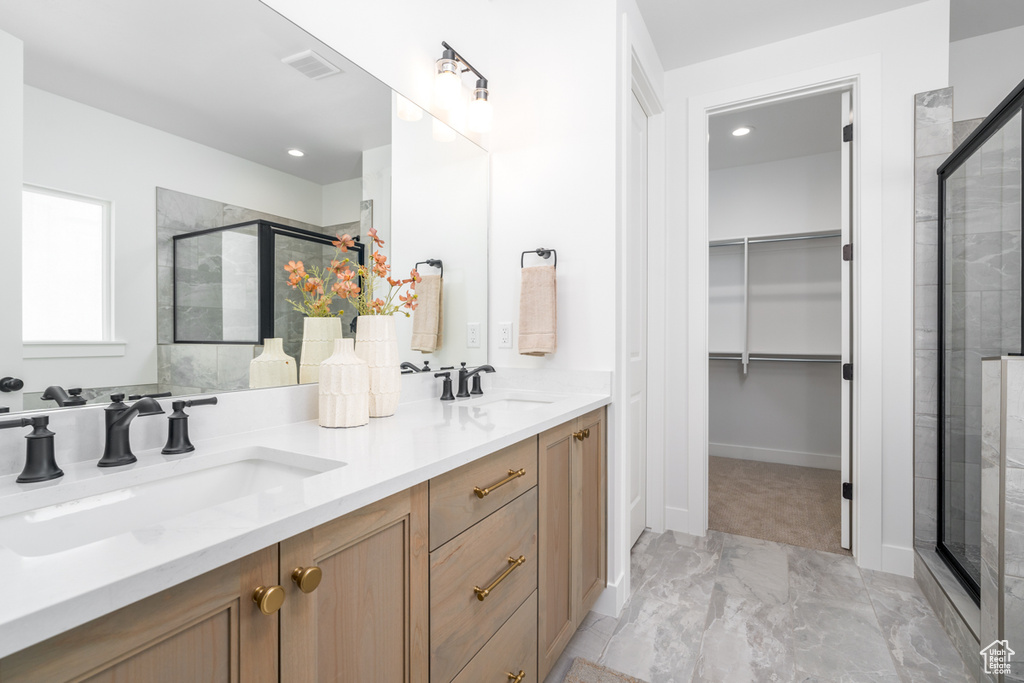 Bathroom featuring an enclosed shower, tile flooring, and double sink vanity