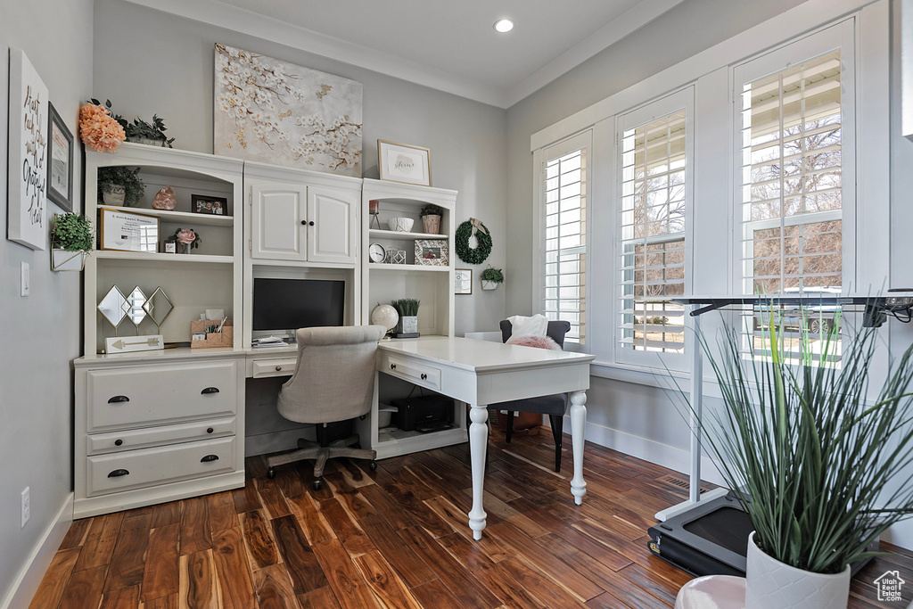 Office area with dark hardwood / wood-style flooring and crown molding