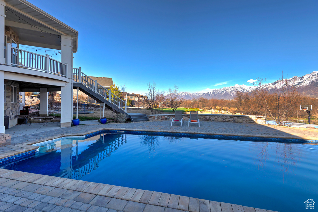 View of swimming pool with a patio area and a mountain view